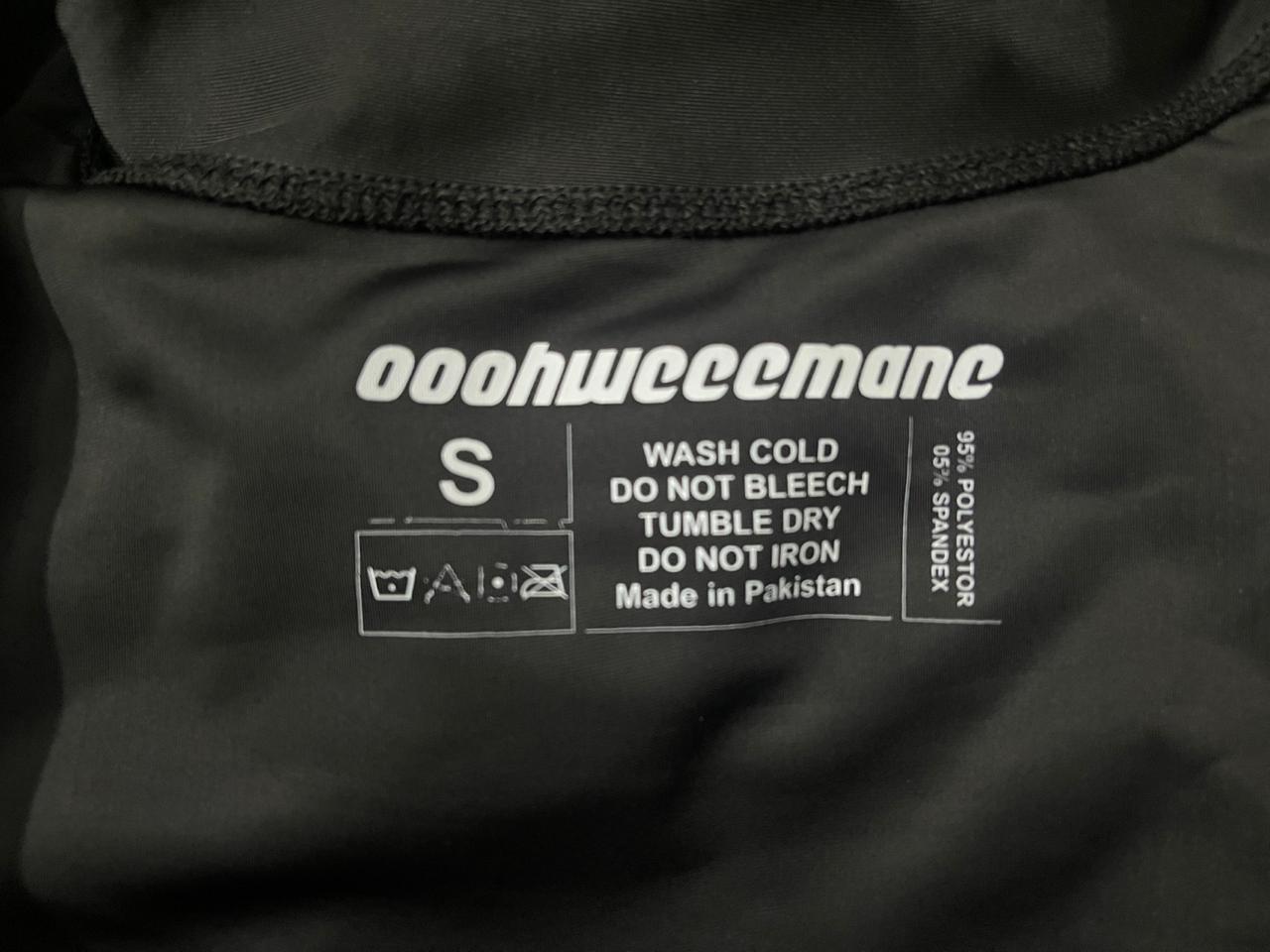 Clothing label with brand name and care instructions on a black fabric background